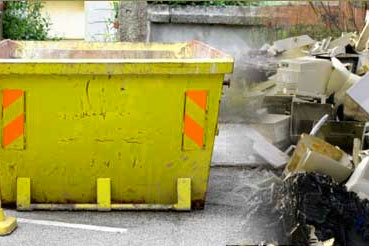 Skip with rubbish pile beside it